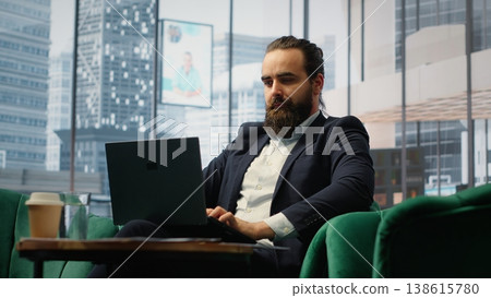 Visionary male leader working in a cityscape luxurious office, planning budget management and global business development. Young career driven entrepreneur checks market trends. Camera B. Visionary male leader working in a cityscape luxurious office, planning budget management and global business development. Young career driven entrepreneur checks market trends. Camera B. 138615780