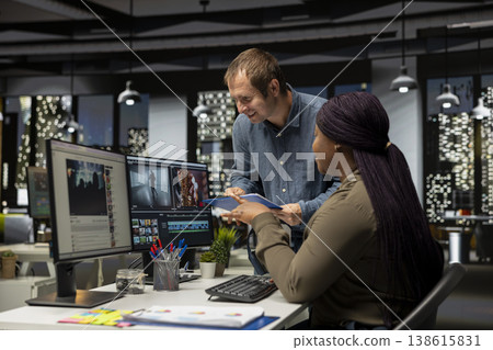 Man and woman filmmakers editing video shoot in post production, using modern tech setup and editing software for a creative video project. Modern workspace with dual monitors. Man and woman filmmakers editing video shoot in post production, using modern tech setup and editing software for a creative video project. Modern workspace with dual monitors. 138615831