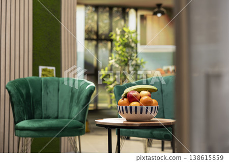Cozy residential flat, interior with no people, empty living room, kitchen space, modern elegant style. Wooden furniture, sofa and armchair, coffee table with fruits, warm domestic ambiance. Cozy residential flat, interior with no people, empty living room, kitchen space, modern elegant style. Wooden furniture, sofa and armchair, coffee table with fruits, warm domestic ambiance. 138615859