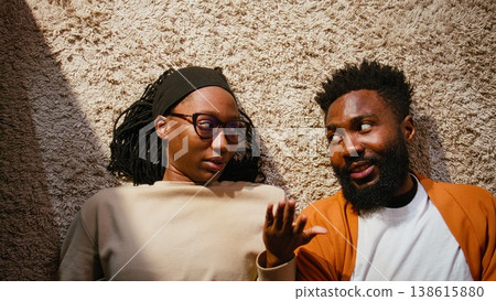 Top down of African American couple fighting in a hallway at home, engaged in a loud domestic quarrel. Man and woman look enraged, frustrated and unhappy, showing relationship conflict. Top down of African American couple fighting in a hallway at home, engaged in a loud domestic quarrel. Man and woman look enraged, frustrated and unhappy, showing relationship conflict. 138615880
