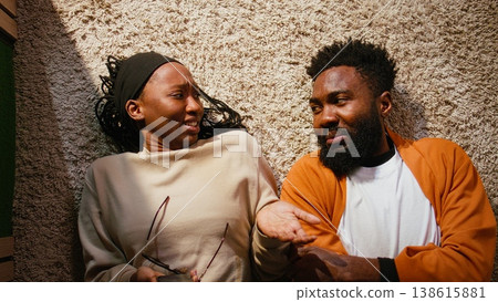 Top down view, African american couple, heated angry quarrel, expressing frustration, domestic life tension, laying on the hallway floor and arguing. Man and woman in relationship drama. Top down view, African american couple, heated angry quarrel, expressing frustration, domestic life tension, laying on the hallway floor and arguing. Man and woman in relationship drama. 138615881