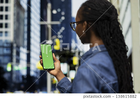 Mockup smartphone used by tourist filming landmarks on city street, visiting travel destination. Woman sightseeing architecture in metropolitan area, taking pictures with green screen phone Mockup smartphone used by tourist filming landmarks on city street, visiting travel destination. Woman sightseeing architecture in metropolitan area, taking pictures with green screen phone 138615882