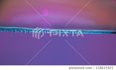 Air bubbles along a blue water surface with purple pink gradient background, clean liquid texture, macro underwater line, freshness concept. Air bubbles along a blue water surface with purple pink gradient background, clean liquid texture, macro underwater line, freshness concept. 138615925