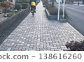A sidewalk paved with herringbone patterned concrete blocks. 138616260
