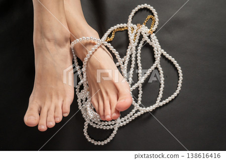 Foot fetish. Bare female feet with pearl beads. Foot fetish. Bare female feet with pearl beads. 138616416