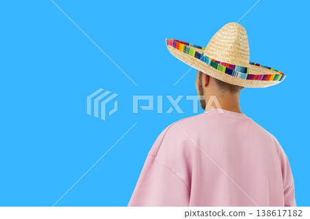 Cinco de Mayo, Young man stands with his back turned, wearing sombrero Cinco de Mayo, Young man stands with his back turned, wearing sombrero 138617182