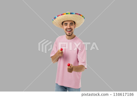 Cinco de Mayo, Young man in sombrero plays maracas in celebration Cinco de Mayo, Young man in sombrero plays maracas in celebration 138617186