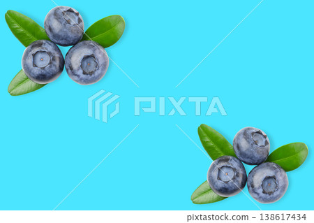 Blueberries with green leaves placed on a blue surface Blueberries with green leaves placed on a blue surface 138617434