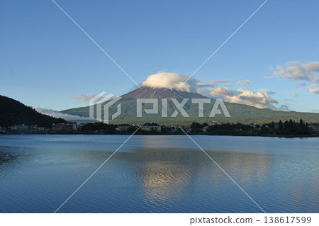 初夏時節，富士山被莢狀雲籠罩，倒映在河口湖面上，湖面在微風中泛起模糊的漣漪，構成了一幅美麗的富士山倒影。 138617599
