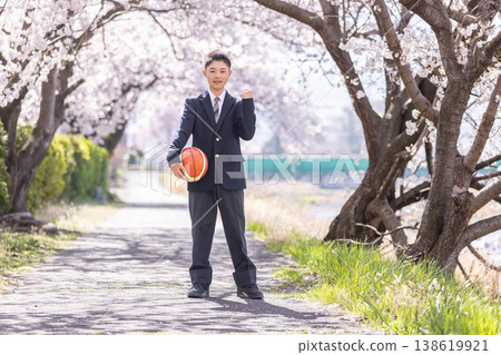 高中生們在盛開的櫻花樹下手持籃球。 138619921
