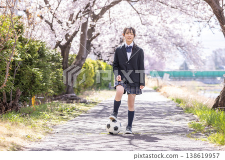 國中女生在櫻花樹下踢足球。 國中女生在櫻花樹下踢足球。 138619957