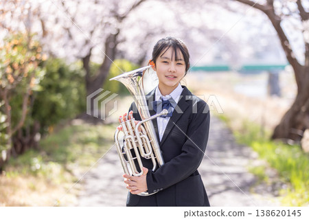櫻花叢中，一位女學生手持銅管樂器。 138620145