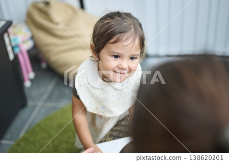 一個蹣跚學步的孩子抬頭微笑的肖像 一個蹣跚學步的孩子抬頭微笑的肖像 138620201