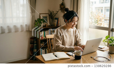 A smiling woman working on her computer at home. 138620286