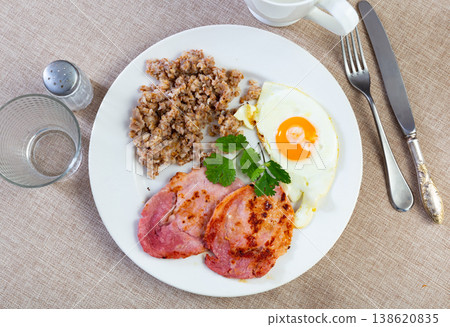 Pork with buckwheat and fried eggs for breakfast 138620835