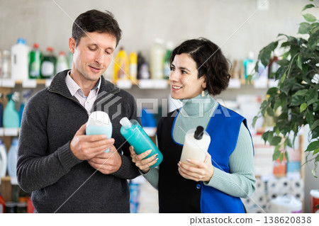 Female saleswoman offers man buy shampoo or shower gel in supermarket Female saleswoman offers man buy shampoo or shower gel in supermarket 138620838