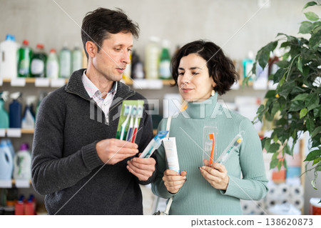Among shop windows, spouses buyers leisurely examines goods and chooses toothbrush Among shop windows, spouses buyers leisurely examines goods and chooses toothbrush 138620873