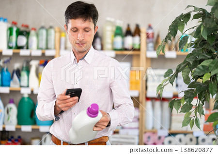 Checking expiration date of detegrent - male shopper scans QR code on label of detegrent using smartphone 138620877