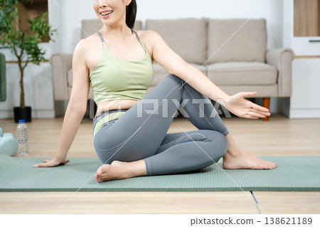 Asian woman practicing yoga and home workout in a bright living space. Healthy lifestyle, fitness, balance, and mindfulness concept with calm and modern atmosphere. Asian woman practicing yoga and home workout in a bright living space. Healthy lifestyle, fitness, balance, and mindfulness concept with calm and modern atmosphere. 138621189