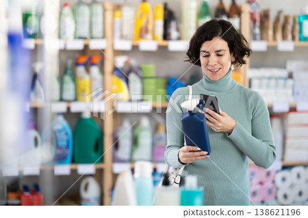 Adult woman scanning qr code for cleaning spray 138621196