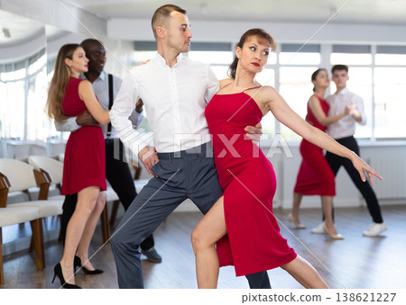 Young man and woman dancing tango in couple during lesson at studio 138621227