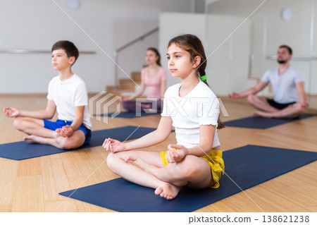 Girl practicing yoga at studio with family Girl practicing yoga at studio with family 138621238