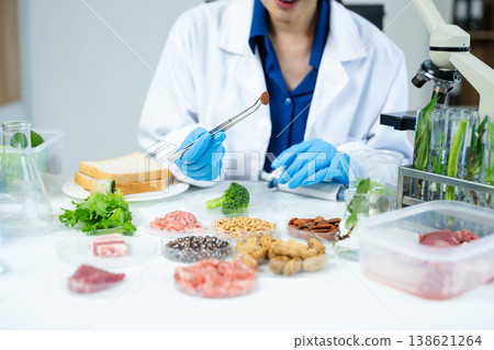 Closeup female scientist testing raw meat in biotechnology lab for food safety, nutrition, and quality research, focusing on food science innovation. 138621264