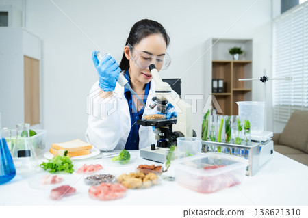 Female scientist analyzing vegetables and food samples in laboratory, researching nutrition, biotechnology, and food safety innovation. Female scientist analyzing vegetables and food samples in laboratory, researching nutrition, biotechnology, and food safety innovation. 138621310
