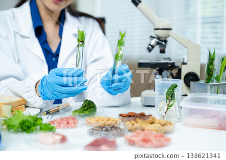 Closeup female scientist testing raw meat in biotechnology lab for food safety, nutrition, and quality research, focusing on food science innovation. Closeup female scientist testing raw meat in biotechnology lab for food safety, nutrition, and quality research, focusing on food science innovation. 138621341