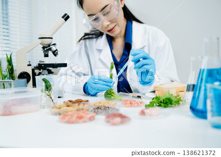 Food scientists woman using microscopes and pipettes in a modern laboratory environment. 138621372