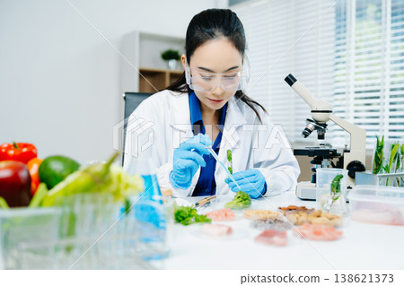 Food scientists woman using microscopes and pipettes in a modern laboratory environment. 138621373