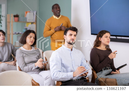 Multinational group listens and takes notes lectures in lecture hall Multinational group listens and takes notes lectures in lecture hall 138621397