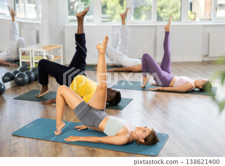 During training girl leads multinational class, performs exercises to strengthen muscles of press During training girl leads multinational class, performs exercises to strengthen muscles of press 138621400