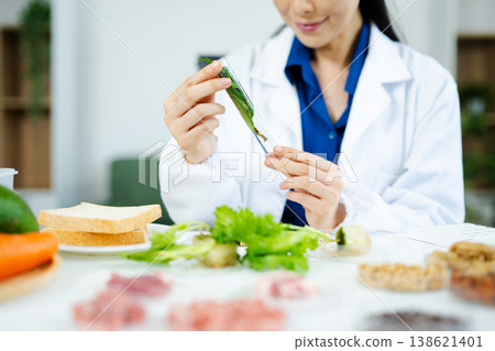 Scientist in a modern lab analyzing food samples with advanced equipment. Perfect for food science, research in  in food science and biotechnology 138621401