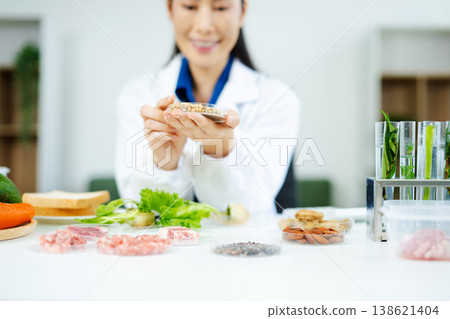 Scientist in a modern lab analyzing food samples with advanced equipment. Perfect for food science, research in in food science and biotechnology Scientist in a modern lab analyzing food samples with advanced equipment. Perfect for food science, research in in food science and biotechnology 138621404