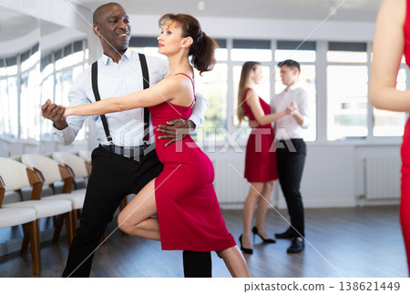 African American man nd woman in red rehearsing elegant tango in pair 138621449