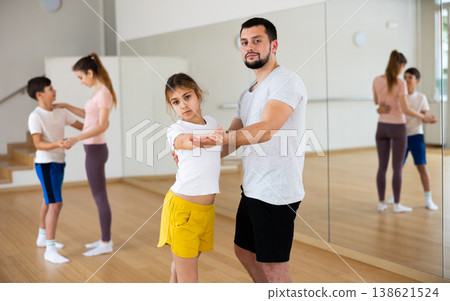 Teen girl learning to dance waltz in pair with father in studio Teen girl learning to dance waltz in pair with father in studio 138621524