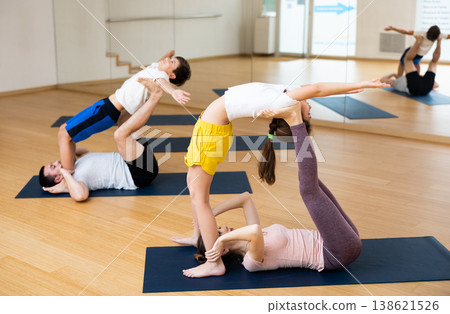 Kids and parents doing stretching exercises during yoga training 138621526