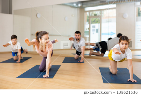 Tween girl performing Balancing Table pose during family yoga class Tween girl performing Balancing Table pose during family yoga class 138621536