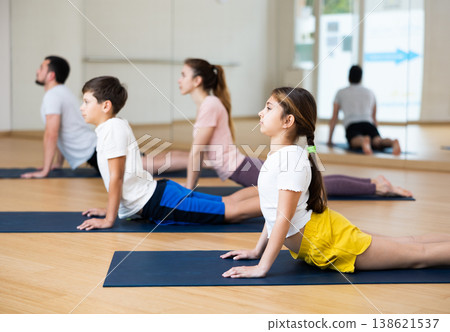 Family of four practicing yoga at gym Family of four practicing yoga at gym 138621537