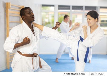Adult man and young woman training judo techniques Adult man and young woman training judo techniques 138621563