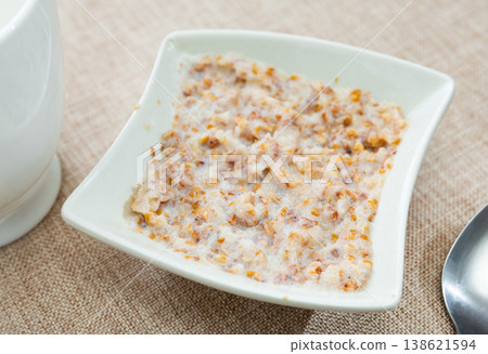 Buckwheat porridge with milk in bowl closeup 138621594