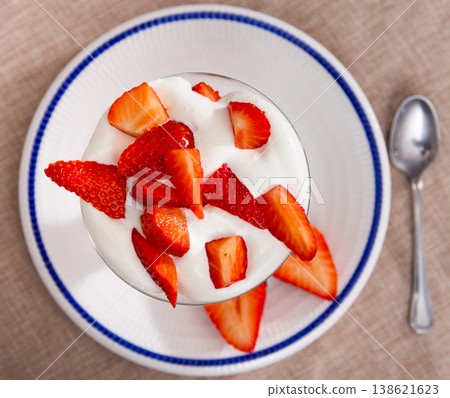 Whipped cream with strawberries in glass cup 138621623