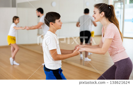 Young boy dancing waltz with his mother in gym Young boy dancing waltz with his mother in gym 138621624