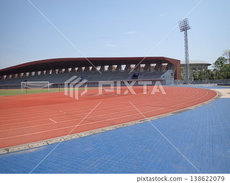 A sports facility scene featuring a track and field stadium with spectator seating. A sports facility scene featuring a track and field stadium with spectator seating. 138622079