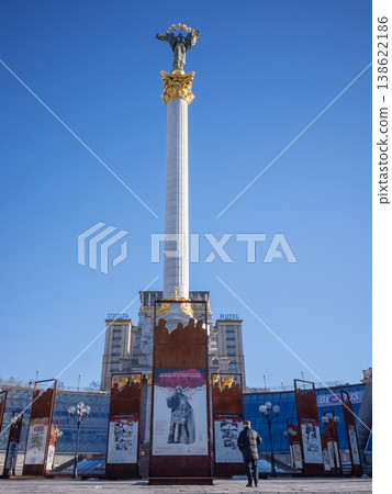 [Ukraine] Brown panels lining Maidan Square in Kyiv, the capital, the statue of the goddess Berechnia, and a clear blue sky. 138622186