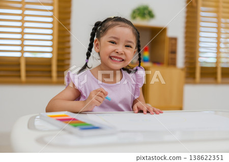 happy preschool child girl drawing and painting with colorful oil pastels on paper happy preschool child girl drawing and painting with colorful oil pastels on paper 138622351