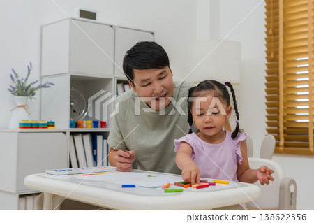 Caption/Description: father and child girl drawing and painting with colorful oil pastels on paper Caption/Description: father and child girl drawing and painting with colorful oil pastels on paper 138622356