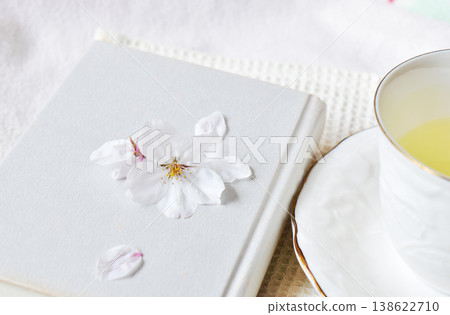 Cherry blossoms on a book and a teacup Cherry blossoms on a book and a teacup 138622710