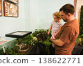 A man and a little girl are looking at a terrarium 138622771